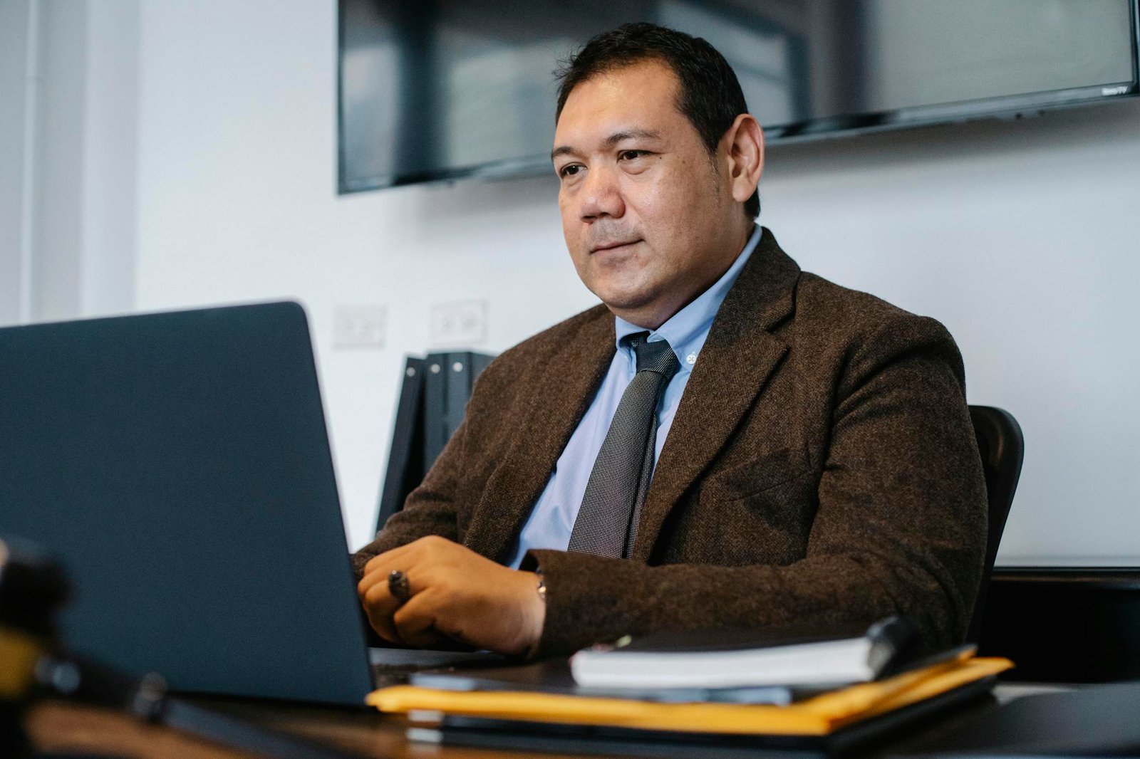 Focused ethnic businessman using netbook while working in office